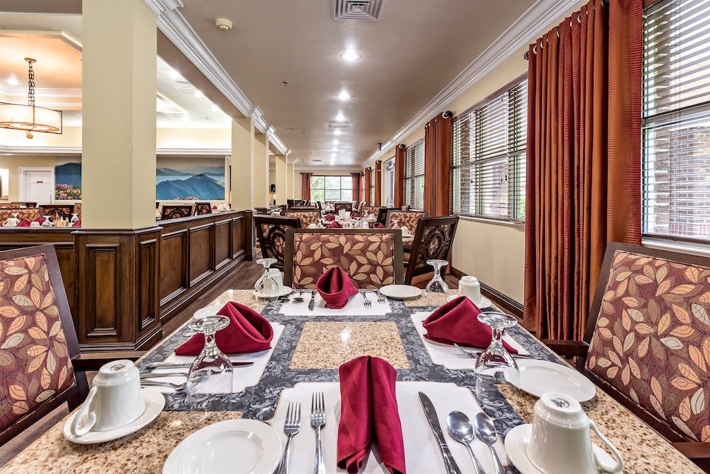 An elegantly set dining table in a spacious restaurant interior.