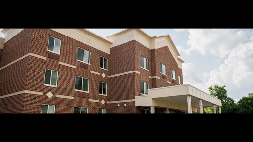 A modern brick building featuring multiple windows and a welcoming entrance.
