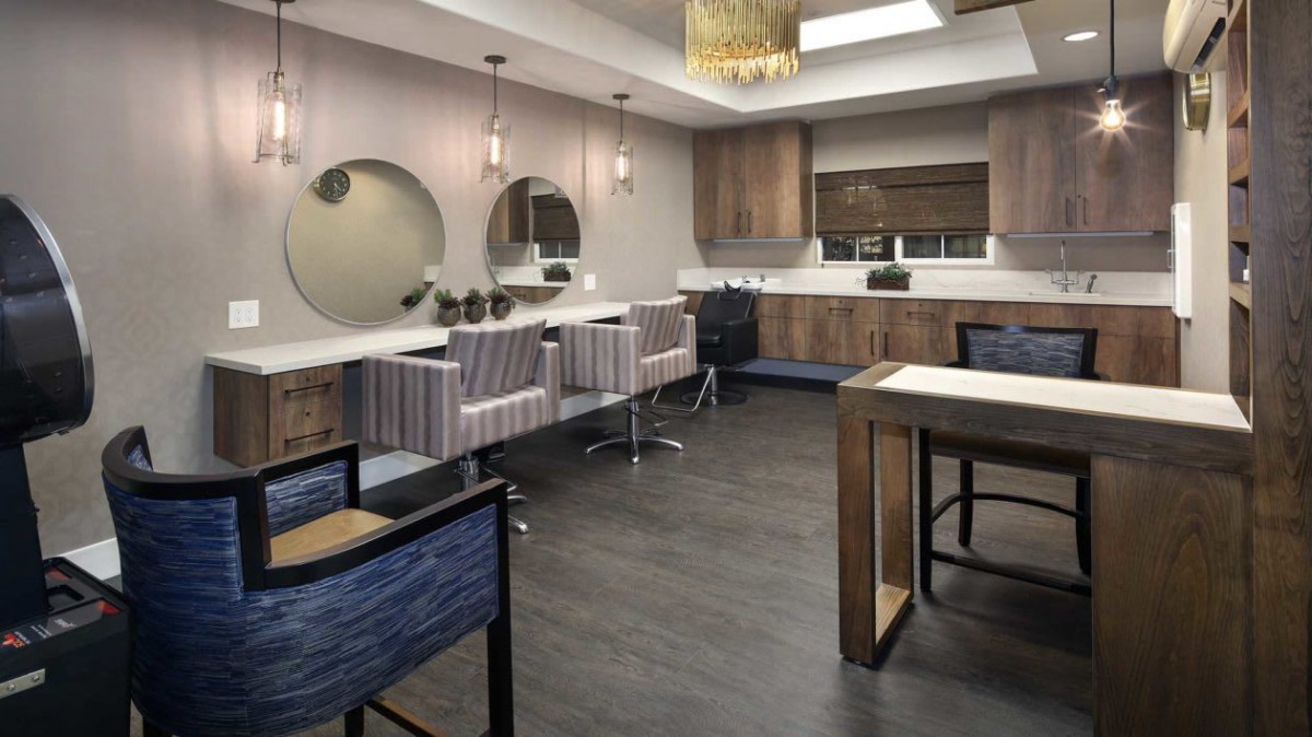 A modern salon interior with stylish furniture and decorative mirrors.