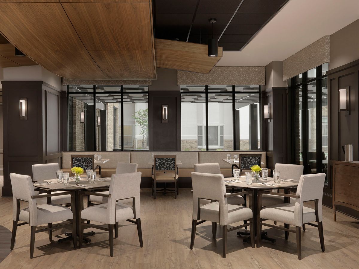 A modern restaurant interior with elegant seating and large windows.
