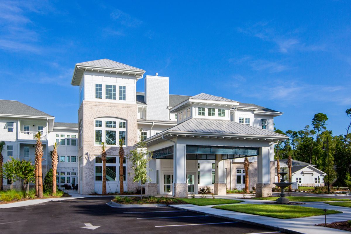 A modern residential building with a blue sky backdrop.