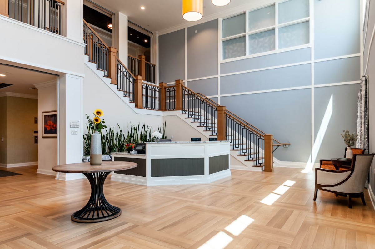 A modern lobby featuring a grand staircase and reception desk with stylish decor.