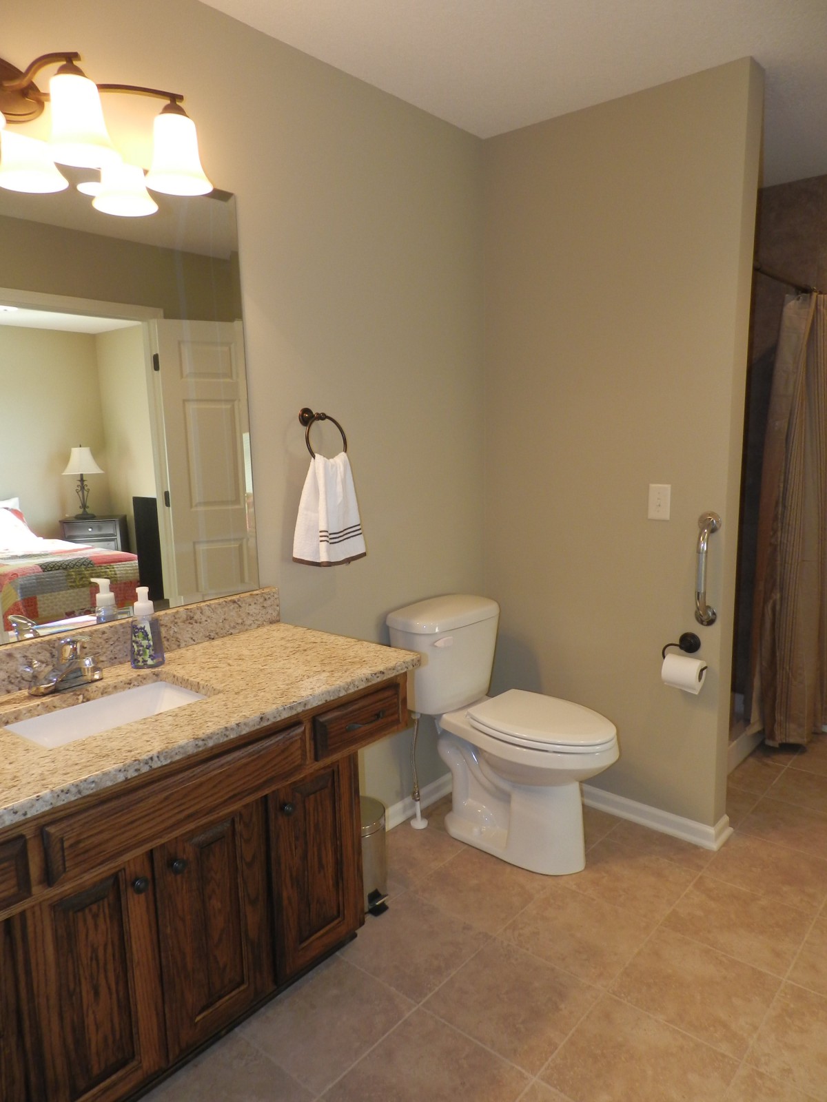 A tidy bathroom featuring a sink, toilet, and mirror.