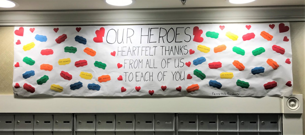 A banner expressing heartfelt thanks to heroes, decorated with colorful hearts and shapes.