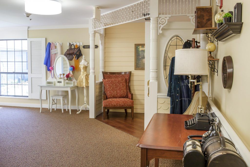 A vintage-themed room featuring classic furniture, a typewriter on the desk, and decorative mirrors.