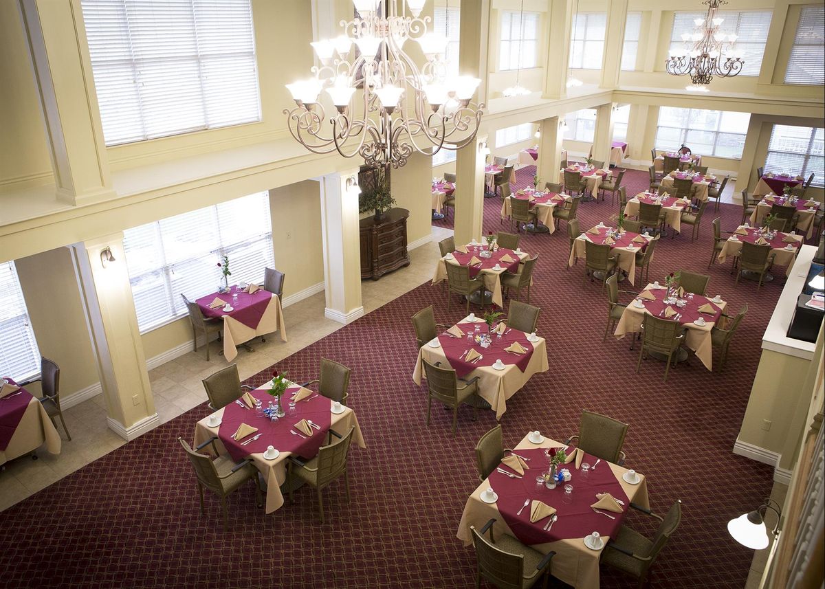 Elegant dining room with chandeliers and neatly set tables.