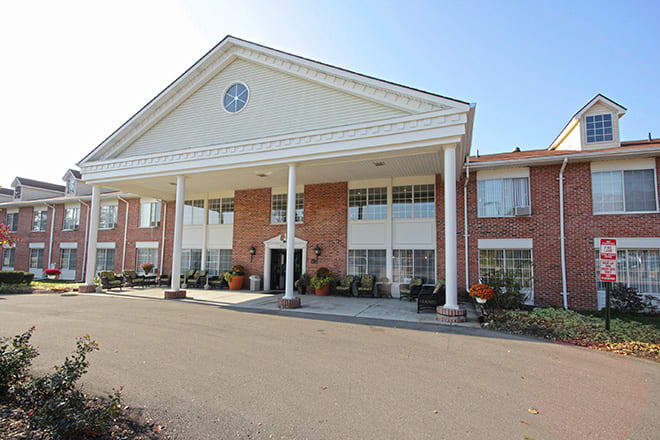 A two-story building with large white columns and a brick facade.