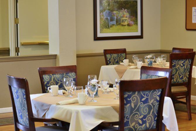 An elegantly set dining room with neatly arranged tables and chairs.