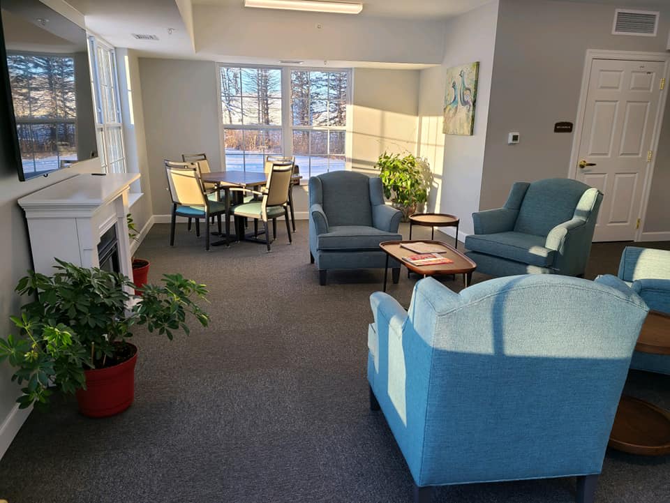 A cozy living room with ample seating and natural light streaming through the windows.