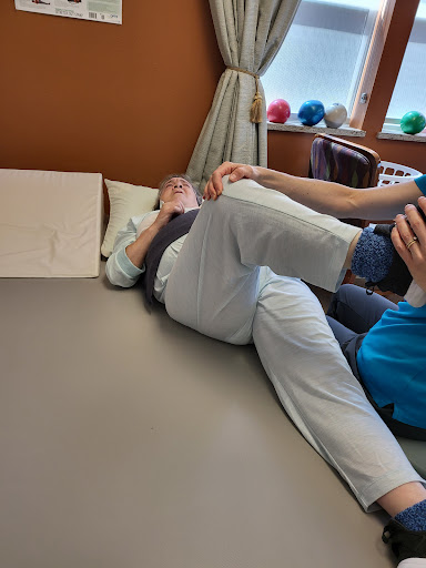 A physical therapist assists a patient with leg exercises during a rehabilitation session.