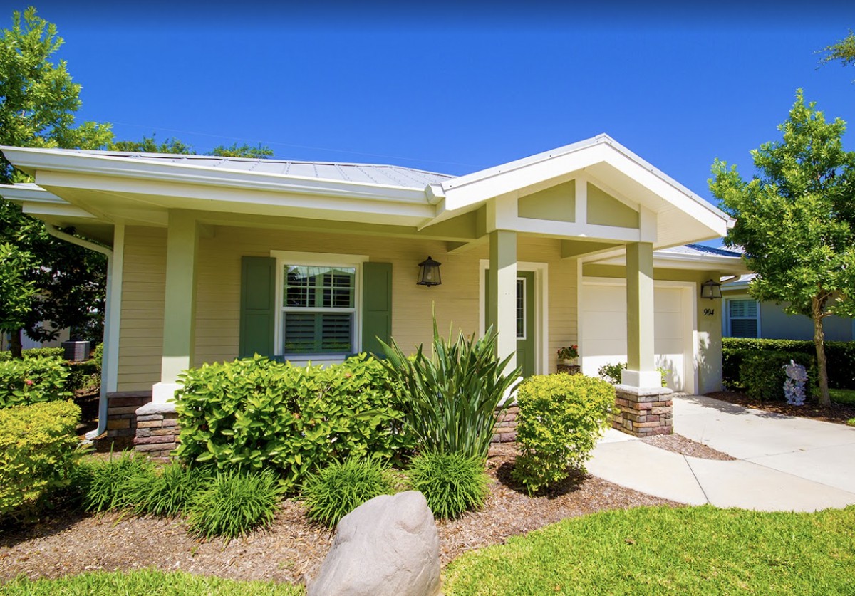 A charming residential house with landscaped front yard on a sunny day.