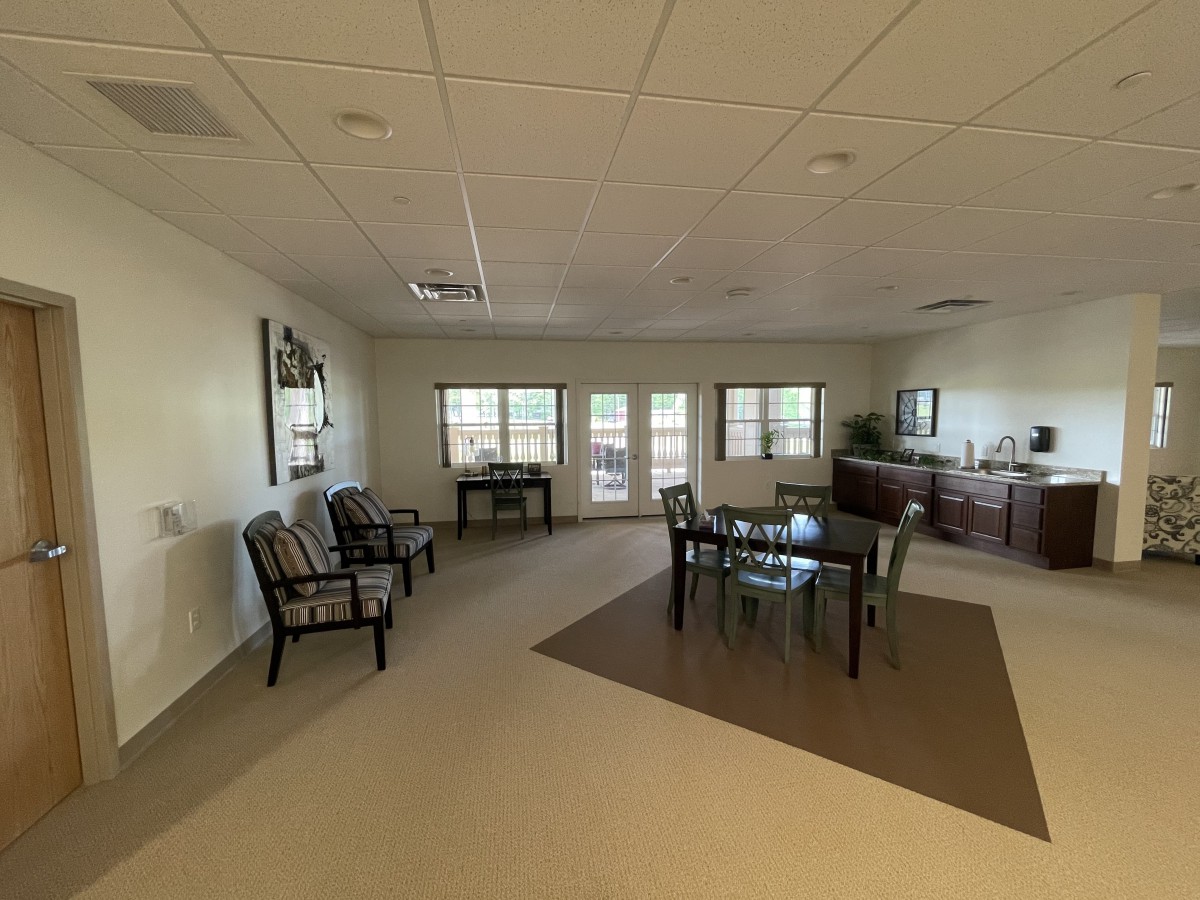 A spacious interior with a dining area featuring a table and chairs, large windows, and additional seating.