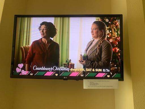 A scene from a Christmas-themed movie featuring two women in a festive indoor setting.