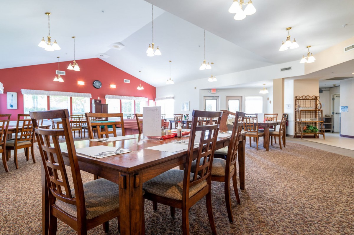 A spacious dining room with wooden tables and chairs.