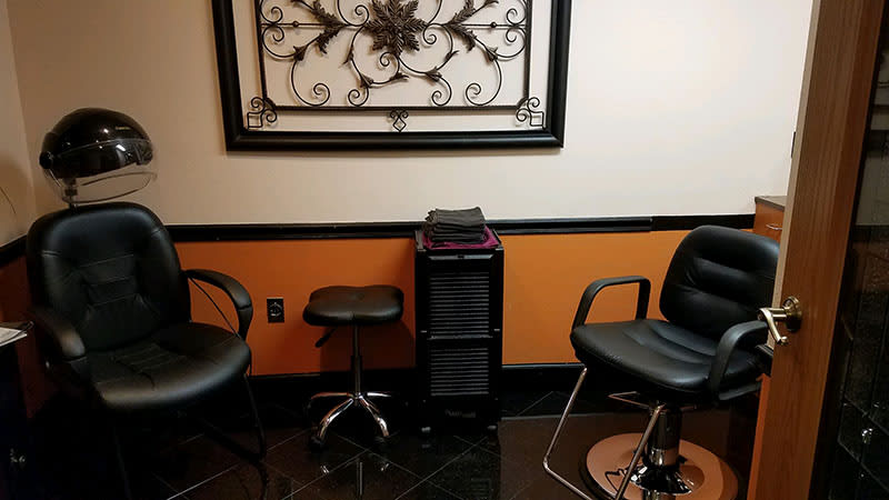 A stylish salon interior featuring chairs and a decorative wall piece.