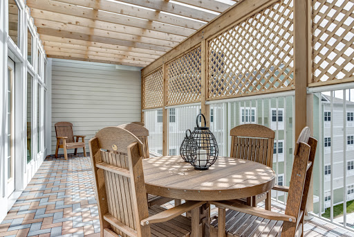 A serene outdoor patio featuring wooden furniture and latticework, perfect for dining and relaxation.