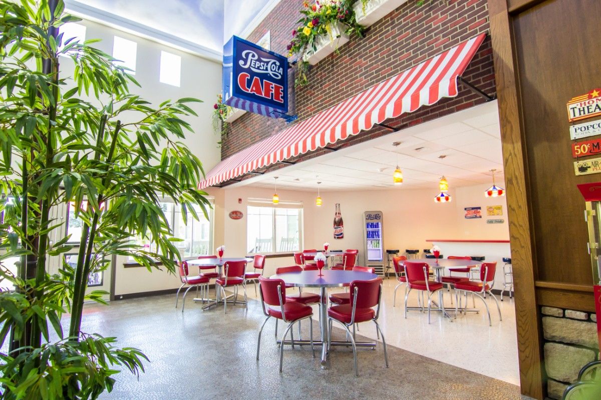 A retro-themed cafe with red and white decor, featuring vintage-style seating and a welcoming atmosphere.