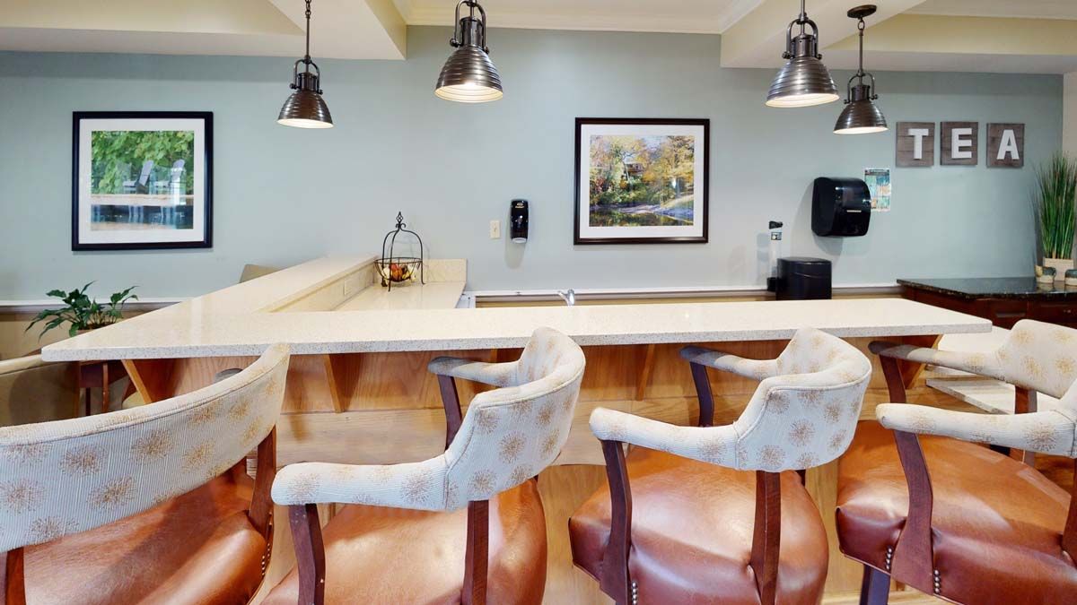 A modern bar setup featuring comfortable chairs and stylish lighting.