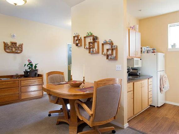 A cozy dining area with wooden furniture and adjacent kitchen.