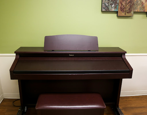 A stylish piano setup against a vibrant green wall.