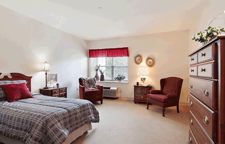 A cozy bedroom with elegant furniture and a red-accented window.