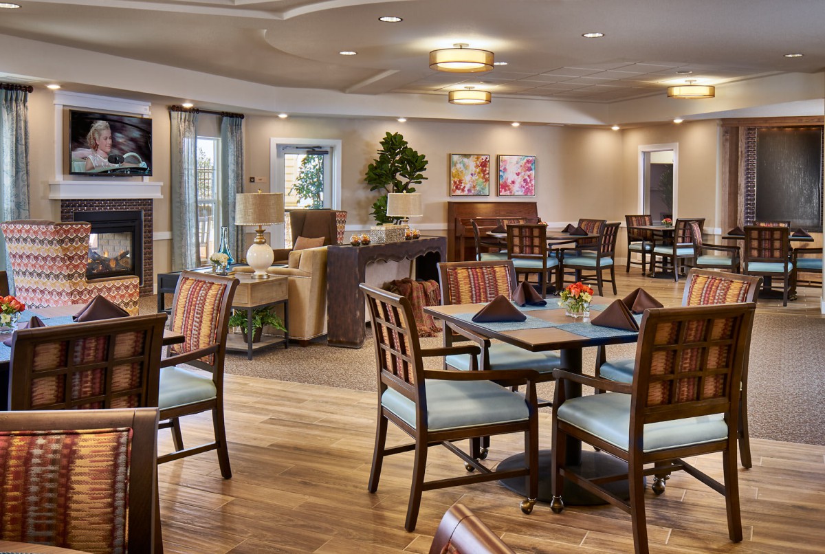 A modern dining area with neatly arranged tables and chairs, featuring contemporary decor and lighting.