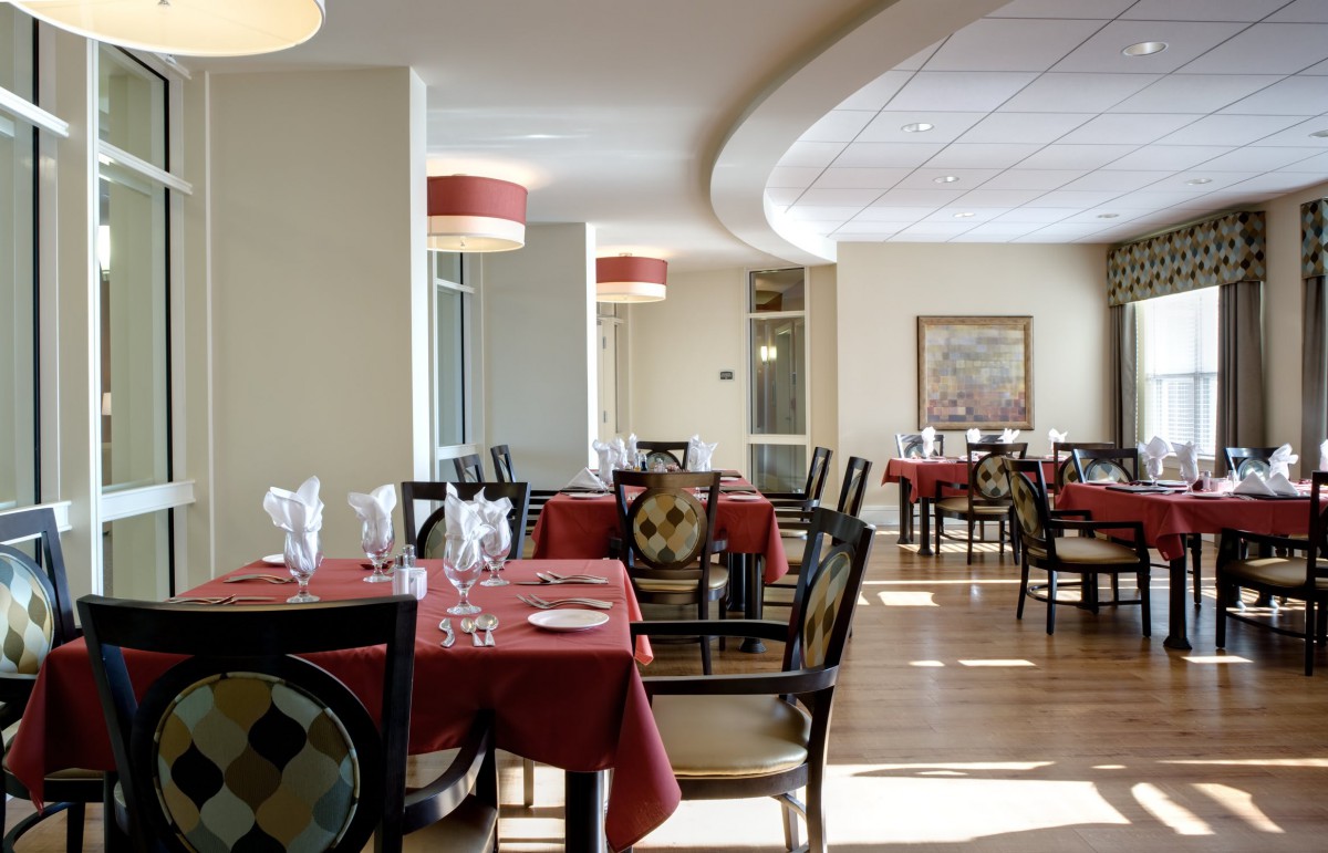 A well-set dining area in a restaurant with red tablecloths and elegant decor.