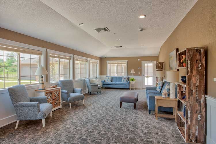 A spacious and well-lit living room with comfortable seating and large windows.