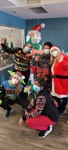 A joyful group celebrating the holiday season in festive attire, including Santa and fun sweaters.