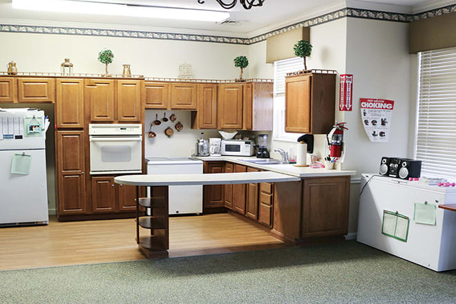 A kitchen with wooden cabinets, appliances, and a countertop.