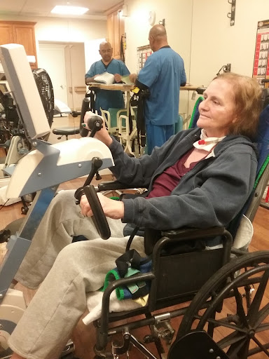 A patient engaged in rehabilitation exercises while seated in a wheelchair.