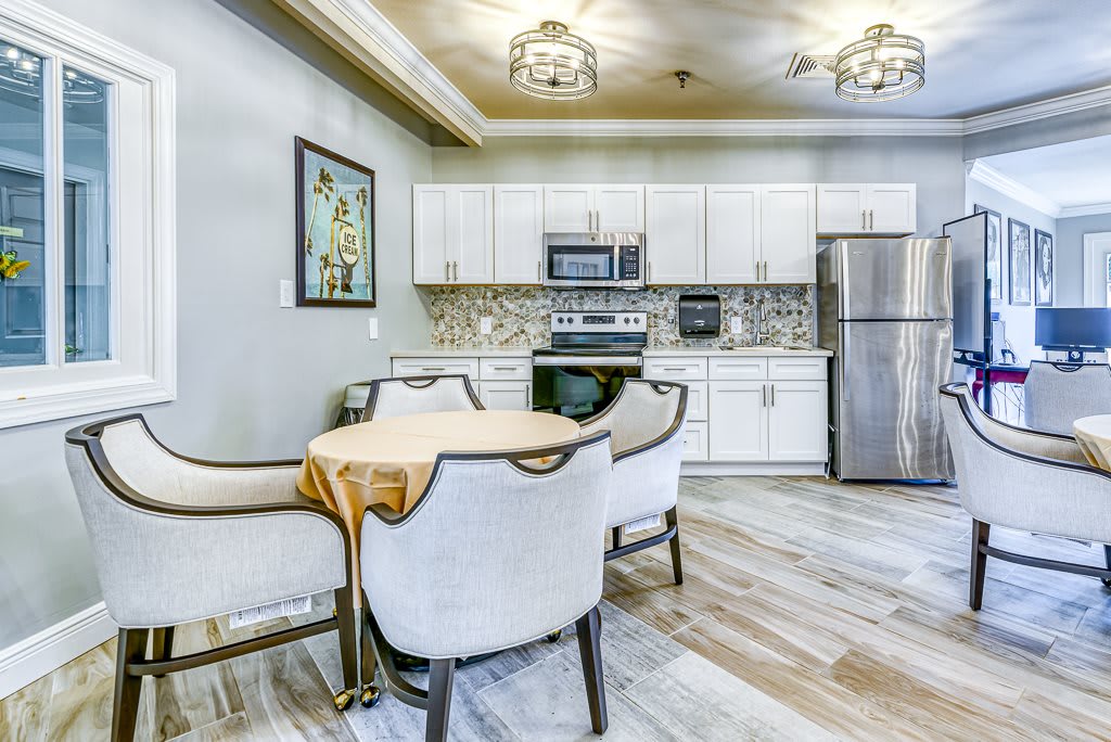 A modern kitchen with white cabinets and a cozy dining area.