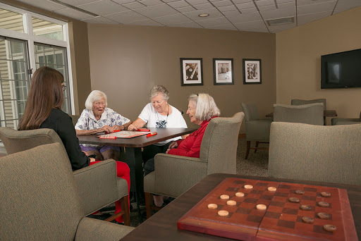 A group of elderly women enjoying a game of checkers in a cozy community setting.