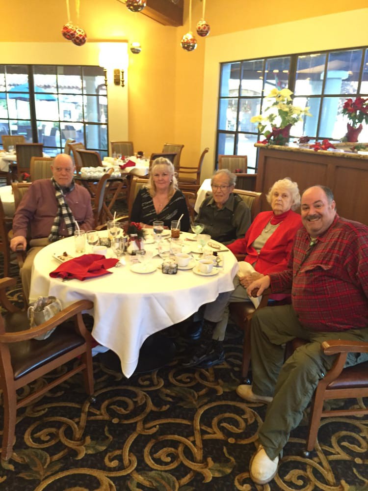 A group of people sitting around a table in a restaurant, enjoying a meal together.