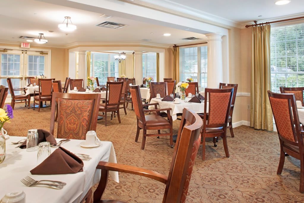 A formal dining room with elegant wooden chairs and neatly set tables.