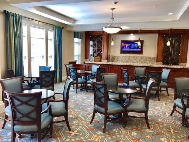 A spacious and well-lit lounge area with comfortable seating and a television.