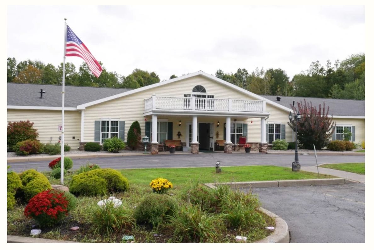 A building with an American flag and a landscaped garden in front.