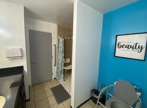 A bright and modern bathroom space featuring a shower area and a vibrant blue accent wall.