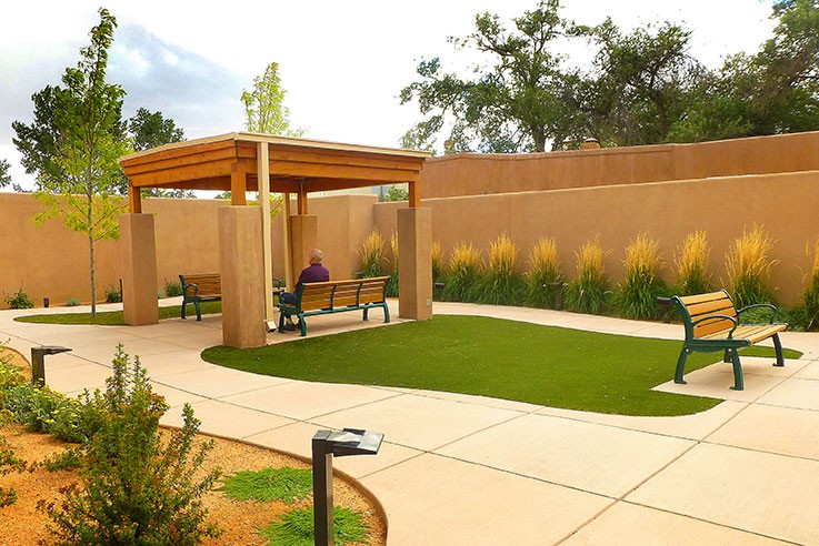 A serene outdoor garden with a gazebo and benches along a winding pathway.