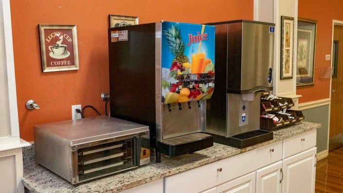 A beverage station featuring a juice dispenser and other kitchen equipment.