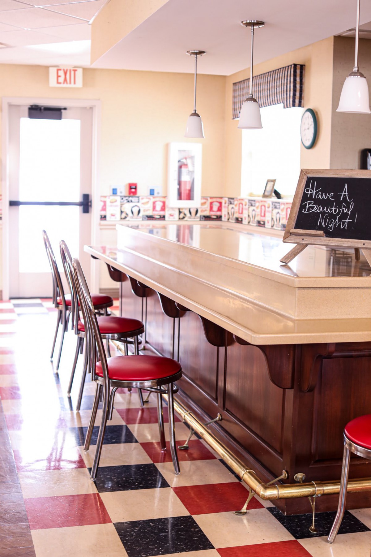 A retro-style diner with red bar stools and a classic counter.