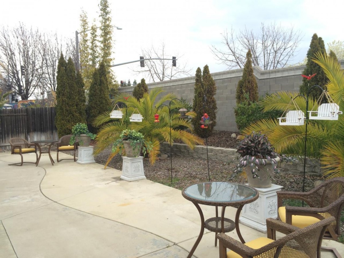 Outdoor patio area with tables, chairs, and potted plants.