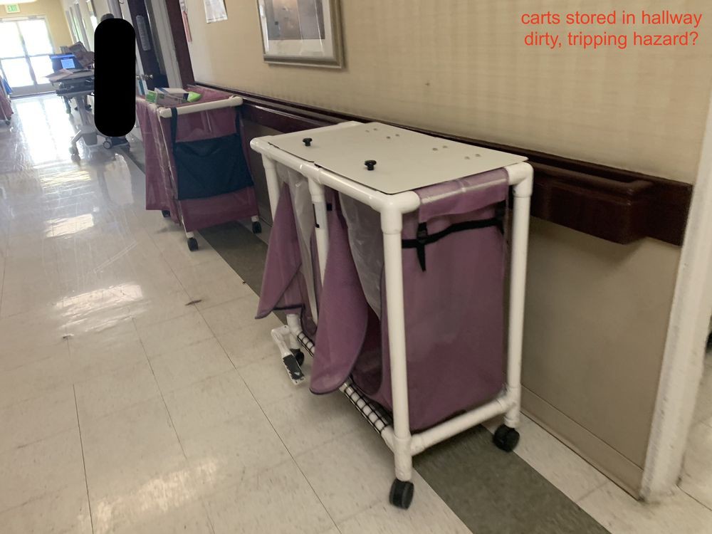 A wheeled laundry cart in a hospital corridor.