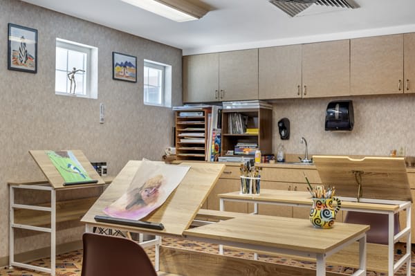 An art classroom with drawing desks and art supplies.