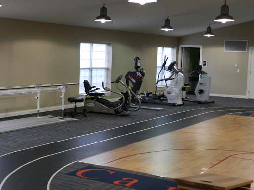 A view of a gym featuring exercise machines and an indoor running track.