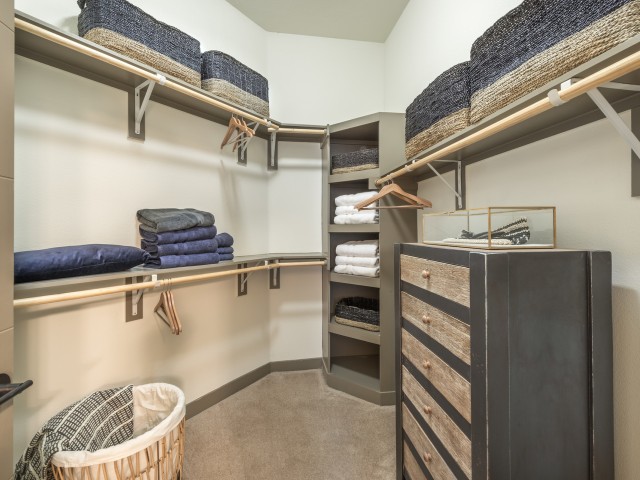 A well-organized closet with shelves, drawers, and a laundry basket.
