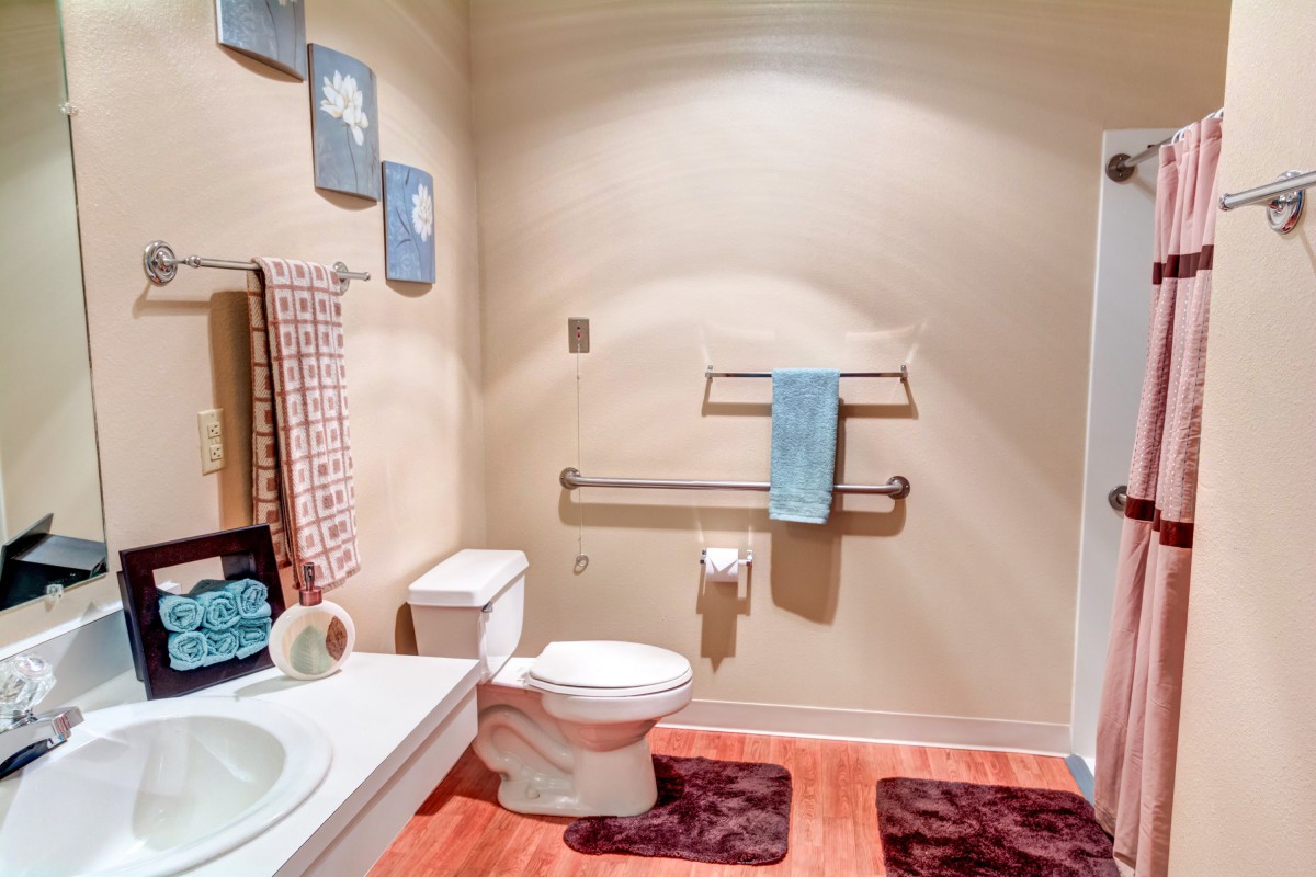 A well-organized bathroom with a toilet, sink, and decorative elements like towels and wall art.