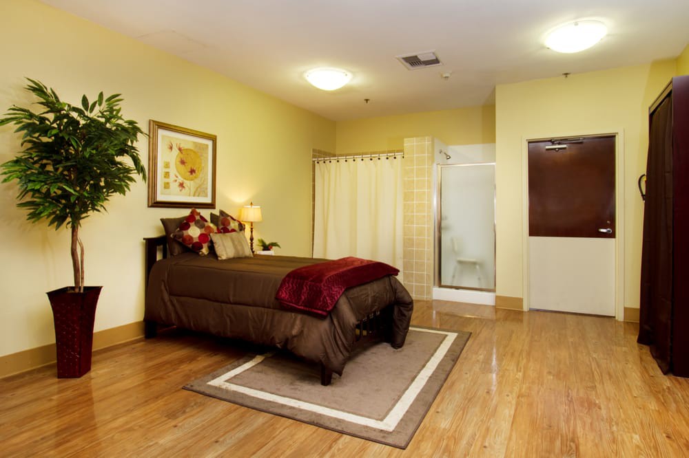 A cozy bedroom with wooden flooring, featuring a comfortable bed and elegant decor.