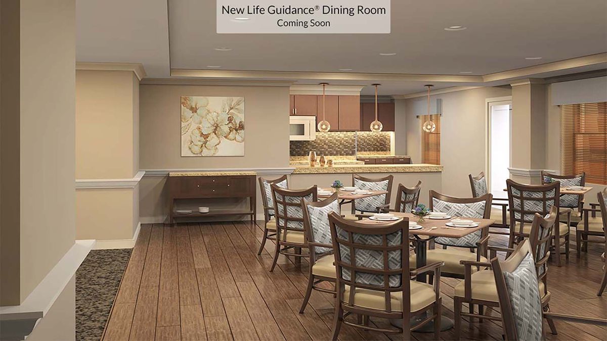 A modern dining room with wood flooring and elegant decor, featuring a kitchen area and stylish furniture arrangement.