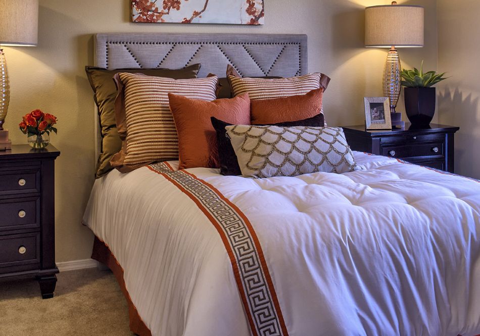 A cozy, well-decorated bedroom with a neatly made bed and stylish pillows.